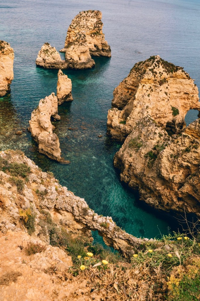 Rocky cliffs and turquoise sea waters with natural arches and formations.